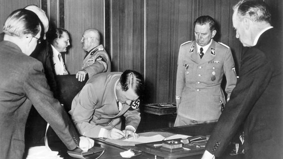 Hitler unterschreibt am 29. September 1938 das "Münchener Abkommen". © picture-alliance / akg-images Foto: akg-images