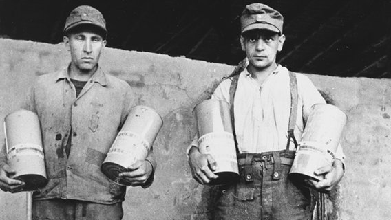 Mitglieder der KZ-Wachmannschaften mit Giftgas-Behältern für die Gaskammern des Lagers. (historische Aufnahme, aufgenommen kurz nach der Befreiung des Lagers 1945) © picture-alliance / akg-images 