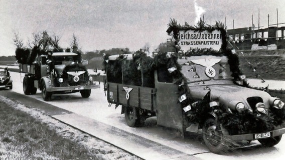 Mit Girlanden und Hakenkreuzen geschmückte Fahrzeuge stehen 1936 auf dem gerade fertiggestellten Teilstück der A 1 zwischen Oyten und Dibbersen. © Heimatverein Oyten 