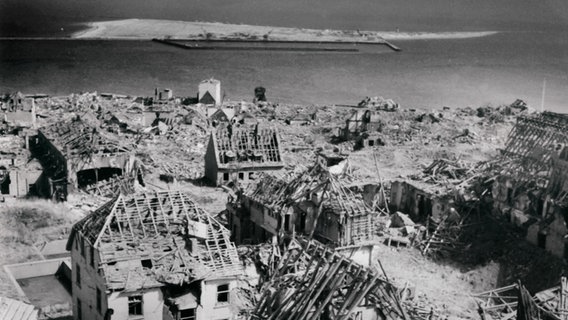 Am 18.04.1945 zerstörte ein britischer Bombenangriff vollständig den Ort Helgoland. Blick vom Leuchtturm über die zerstörte Ortschaft auf die Bade-Düne der Nordseeinsel Helgoland, aufgenommen am 20.04.1947. © picture-alliance / dpa 