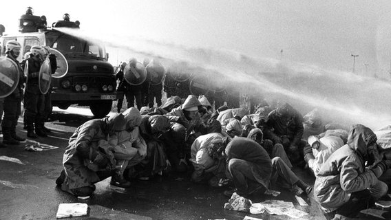 Mit einem Wasserwerfer geht die Polizei am 26. Februar 1981 gegen Demonstranten vor den Toren des Baugeländes des AKW Brokdorf vor. © picture-alliance / dpa Foto: Pfeiffer