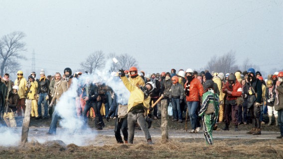 Zum großen Teil vermummte Demonstranten werfen im Rahmen einer Protestaktion gegen das geplante AKW Brokdorf am 28. Februar 1981 Steine und andere Wurfgeschosse. © picture-alliance / dpa Foto: Martin Athenstädt