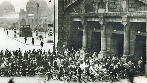Hafenarbeiter warten mit ihren Fahrrädern 1930 vor dem Elbtunnel in St. Pauli vor den Aufzügen. © HPA 