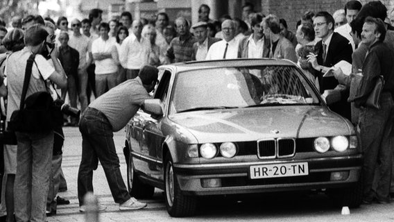 Der Wagen mit den Geiselnehmern Dieter Degowski und Hans-Jürgen Rösner wird am 18.08.1988 in Köln von Journalisten umringt. © picture alliance / dpa Foto: Hartmut Reeh