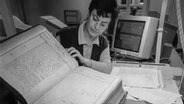 Rechtspflegerin Gudrun Beninde hält das alte Grundbuch von 1870 in der Hand. © dpa/zb Foto: Waltraud Grubitzsch