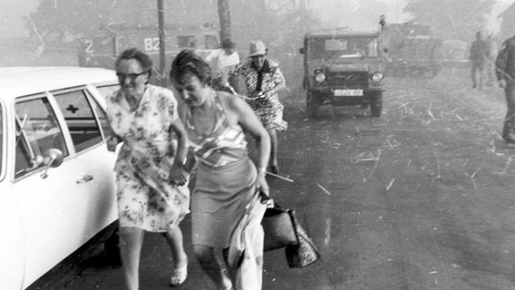 Anwohnerinnen flüchten im August 1975 vor dem herannahenden Feuer zu Fuß aus ihren Häusern im Landkreis Celle. © dpa - Bildfunk Foto: Wolfram Ehrhardt