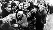 Eine alte Frau bricht im Kriegsjahr 1916 in der Schlange vor einem Lebensmittelgeschäft vor Hunger zusammen. © dpa - Bildarchiv 