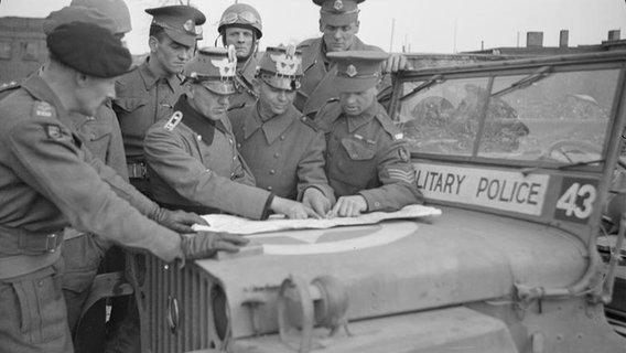 Angehörige der britischen Militärpolizei geben Hamburger Polizisten im Mai 1945 Instruktionen. © IWM BU 5084 