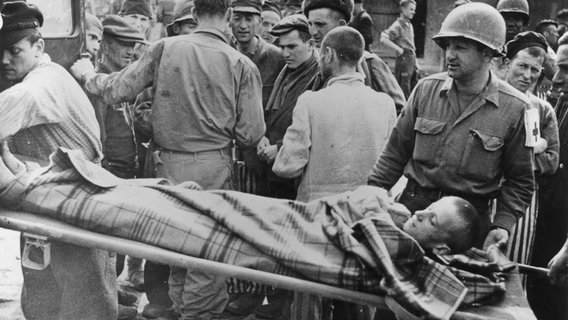 Angehörige der U.S.Army laden nach der Befreiung des KZ Buchenwald im April 1945 einen auf einer Trage liegenden kranken Häftling in einen Krankenwagen ein. © Yad Vashem, Jerusalem / Public Domain 