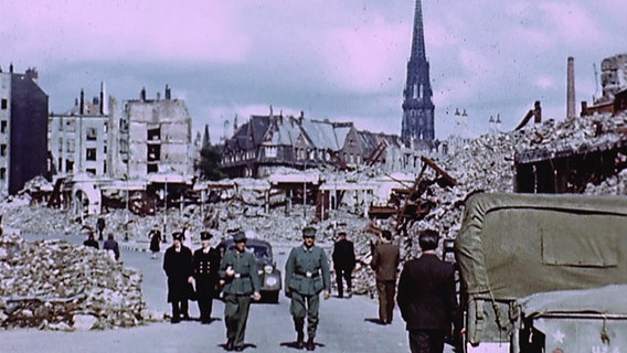Bild des zerstörten Hamburg, gedreht vom späteren Hollywoodregisseur George Stevens. Im Hintergrund ist die Nicolaikriche zu sehen, auf der Straße Männer in deutschen Uniformen. Sie hatten nicht anderes anzuziehen. © NDR/SpiegelTV 