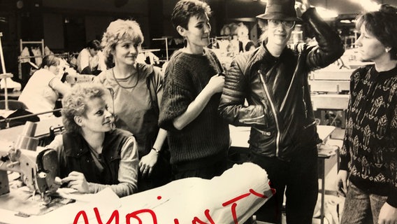 Christiane Stürmer, Mitarbeiterin des VEB Jugendmode Shanty, probiert 1987 für einen Fototermin die ersteigerte Lederjacke von Udo Lindenberg an. © Kulturhistorisches Museum Rostock 