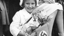 Deutsches Mädchen mit Hakenkreuzfahne 1940. © picture-alliance / akg-images 