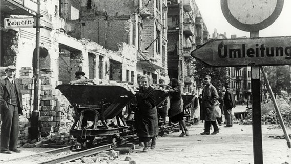 Sogenannte Trümmerfrauen entsorgen in den Jahren nach dem Zweiten Weltkrieg Schutt mit Loren. © picture alliance / akg-images 