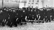 Matrosen auf dem Rückmarsch von einer großen Demonstration in Wilhelmshaven am 10. November 1918. © picture-alliance / akg-images 