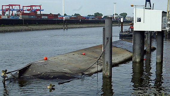 Ein Schiff liegt kieloben in einem Hafenbecken © picture alliance / AP Photo 