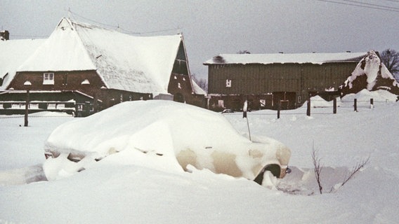 Ein von der Außenwelt abgeschnittenes Gehöft in Schleswig-Holstein am 3. Januar 1979, im Vordergrund ein eingeschneites Auto. © dpa - Bildarchiv Foto: Heidtmann