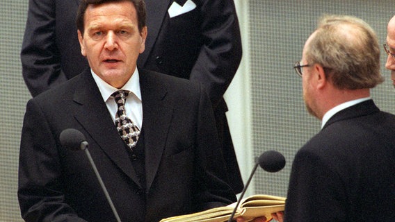 Bundeskanzler Gerhard Schröder spricht am 27.10.1998 im Bundestag in Bonn seinen Amtseid, rechts Bundestagspräsident Wolfgang Thierse. © picture-alliance / dpa Foto: Tim Brakemeier