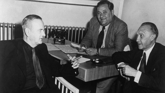 Der SPD-Vorsitzende Kurt Schumacher (links) am 10. September 1949 während einer Besprechung mit Konrad Adenauer (rechts) im Bundeshaus in Bonn. Im Hintergrund Carlo Schmid (SPD). © picture alliance / akg Foto: akg-images