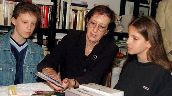 Die ehemalige schleswig-holsteinische Ministerpräsidentin Heide Simonis sitzt am Sozialen Tag 1998 zwischen zwei Schülerinnen in ihrer Wohnung. © picture alliance/ dpa Foto: Wulf Pfeiffer