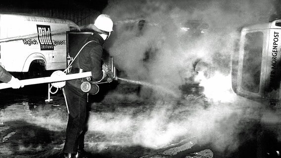 Feuerwehrmänner löschen brennende Fahrzeuge © picture-alliance 