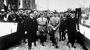 Adolf Hitler am 5. Mai 1937 auf dem Weg zur Taufkanzel in Begleitung von Robert Ley und Blohm junior. © picture-alliance / akg-images Foto: akg-images