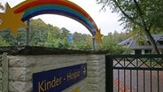 Neben der Einfahrt zum Kinder-Hospiz Sternenbrücke in Hamburg hängt ein Regenbogen, der auch das Logo der Einrichtung ist. © picture alliance / dpa Foto: Ulrich Perrey