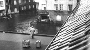 Ein Mann blickt vom Dach auf die überschwemmte Fähr- und Dierksstraße in Hamburg-Wilhelmsburg nach der Sturmflut 1962. © NDR Foto: Günther Hachmeister