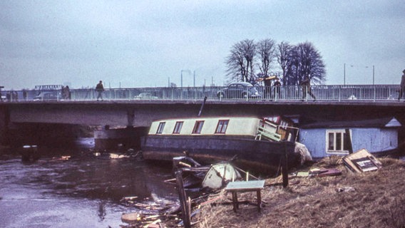 Zerstörte Boote liegen nach der Sturmflut im Februar 1962 angeschwemmt vor einer Brücke. © NDR Foto: Karl-Heinz Pump