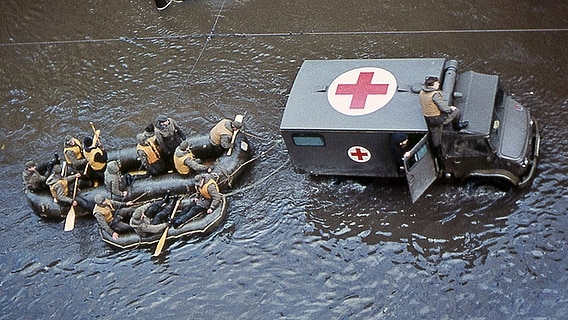 Blick auf ein Rettungsfahrzeug und Schlauchboote in der überfluteten Veringstraße in Hamburg-Wilhelmsburg nach der Sturmflut 1962. © NDR Foto: Karl-Heinz Pump
