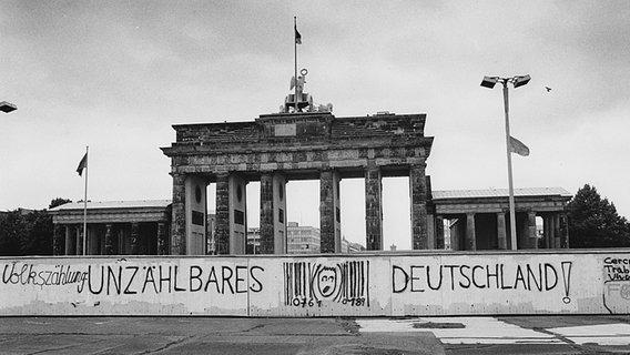 Vor dem Brandenburger Tor haben Unbekannte 1987 einen Slogan an die Berliner Mauer gesprüht: "Unzählbares Deutschland". © picture alliance / akg Foto: Henning Langenheim