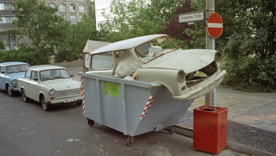 Ein Trabi im Juli 1990 in einem Müllcontainer © dpa / picture-alliance Foto: Peter Kneffel