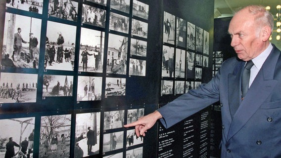 Der Präsident des Kieler Landtags, Heinz-Werner Arens, deutet auf ein Foto in der Wehrmachtsausstellung 1999 © dpa /picture alliance Foto: Wulf Pfeiffer