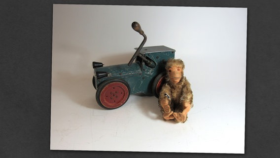 Ein Spielzeugaffe sitzt vor einem Spielzeugauto. © Stiftung Freilichtmuseum am Kiekeberg 