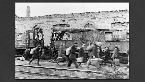 Erfolgreiche Hamsterer huschen an Zugtrümmern vorbei. © Archiv Eisenbahnstiftung 