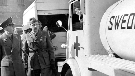 Graf Folke Bernadotte (l.) begutachtet im März 1945 die weißen Fahrzeuge für die geplante Rettungsaktion von KZ-Häftlingen und unterhält sich mit dem Fahrer eines Tankwagens. © picture-alliance/dpa 