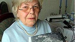 Edith Reinecke mit einer Luftaufnahme des zerstörten Hannover-Misburg. Edith Reinecke mit einer Luftaufnahme des zerstörten Hannover-Misburg. © NDR Foto: Sven Glagow
