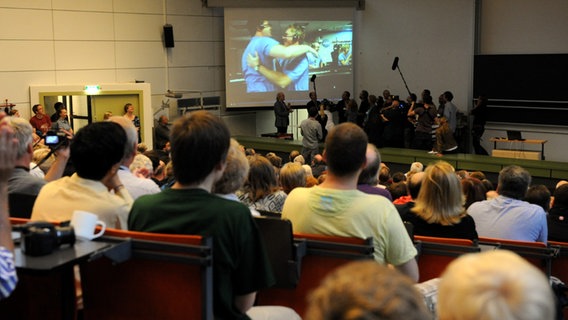 Hunderte Studierende, Mitarbeitende und Familienangehörige verfolgen am 6. August 2012 in einem Hörsaal der Uni Kiel die Landung des Marsrovers Curiosity. © picture alliance / dpa Foto: Carsten Rehder