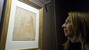 Eine Besucherin einer Ausstellung 2011 in Turin betrachtet ein Selbstporträt von Leonardo da Vinci. © picture alliance / dpa | Di Marco 