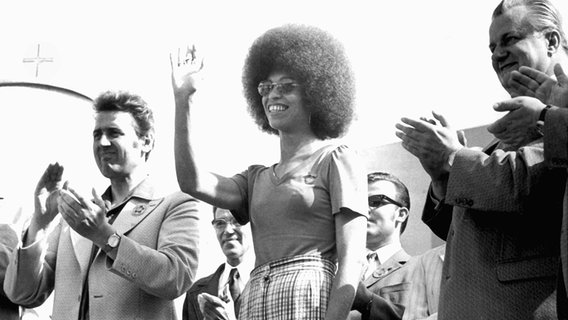 Die amerikanische Bürgerrechtlerin Angela Davis am 31. Juli auf dem Bebelplatz während des "Massenmeetings der Solidarität" zwischen Günter Jahn (l), Vorsitzender des Zentralrates der FDJ, und Werner Krolikowski, Mitglied des ZK der SED. Vom 28. Juli bis zum 5. August 1973 fanden in Ost-Berlin (DDR) die X. Weltfestspiele der Jugend und Studenten statt. Die amerikanische Bürgerrechtlerin Angela Davis am 31. Juli auf dem Bebelplatz während des "Massenmeetings der Solidarität" zwischen Günter Jahn (l), Vorsitzender des Zentralrates der FDJ, und Werner Krolikowski, Mitglied des ZK der SED. Vom 28. Juli bis zum 5. August 1973 fanden in Ost-Berlin (DDR) die X. Weltfestspiele der Jugend und Studenten statt. © picture-alliance / dpa Foto: Giehr