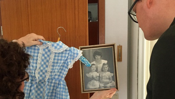 Christel Wittenburg zeigt Hannes Wichmann ein Foto von früher und ein Kleid, das auf dem Foto zu sehen ist. © Barbara Jung Foto: Barbara Jung