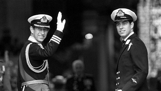29. Juli 1981: Prinz Charles dreht sich beim Betreten der St. Paul's Kathedrale in London noch einmal um und winkt der Bevölkerung zu. Prinz Andrew steht neben ihm. © dpa - Bildarchiv 