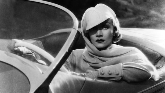 Schauspielerin Marlene Dietrich (1901-1992) in einem Cabriolet im Film "Perlen zum Glück", im Original "Desire", USA 1936, Regie: Frank Borzage, © picture alliance / United Archives | United Archives/Impress 