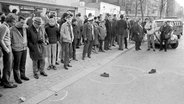 Am Berliner Kurfürstendamm, wo der Studentenführer Rudi Dutschke kurz zuvor niedergeschossen wurde, schauen Passanten am 11. April 1968 auf dessen von der Polizei markierten Schuhe. © picture-alliance / dpa Foto: Chris Hoffmann