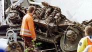 Mitarbeiter eines Räumtrupps bergen am 5. Juni 1998 das Fahrgestell eines zerstörten Waggons des Unglücks-ICE in Eschede. © dpa - Fotoreport Foto: Andreas Altwein
