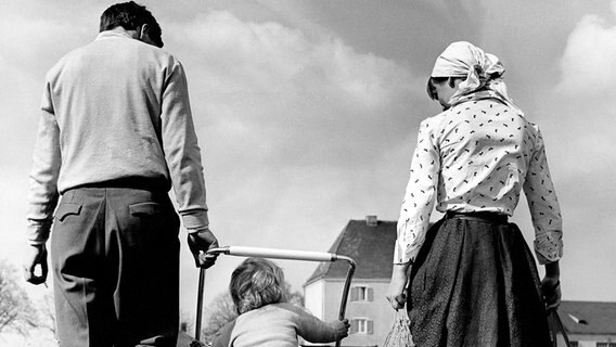 Eine Familie kehrt 1955 zu Fuß von einem Einkauf zurück. © picture alliance / Oscar Poss Foto: Oscar Poss