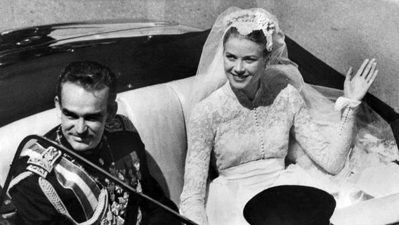 Rainier und Grace Kelly im offenen Hochzeitswagen. Am 19. April 1956 heiratet der Fürst die amerikanische Filmschauspielerin. © dpa - Fotoreport Foto: UPI