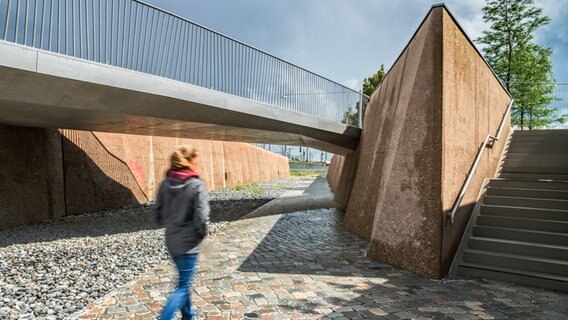 Eine Frau geht an der Fuge des Gedenkortes am ehemaligen Hannoverschen Bahnhof in der Hafencity entlang. © Hafencity Hamburg GmbH Foto: Franziska Husung