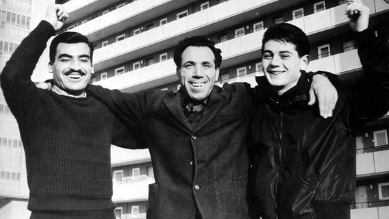 Drei italienische "Gastarbeiter" stehen 1961 vor einem Wohnheim in Braunschweig. © picture-alliance / dpa | DB 