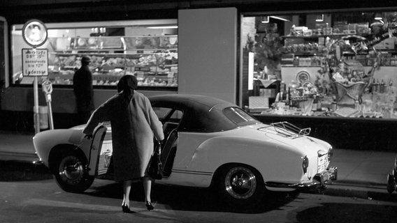 Szenenbild aus dem Film "Wilhelmsburger Freitag" von 1964, bei dem eine Frau in einen Karmann Ghia einsteigt. © picture alliance / United Archives/Pilz Foto: Siegfried Pilz
