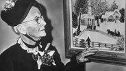 Die amerikanische Farmersfrau und Laienmalerin Anna Maria Robertson Moses (1860-1961), berühmt unter dem Namen Grandma Moses, neben einem ihrer zur Naiven Malerei gehörenden Werke. © picture-alliance / dpa Foto: dpa